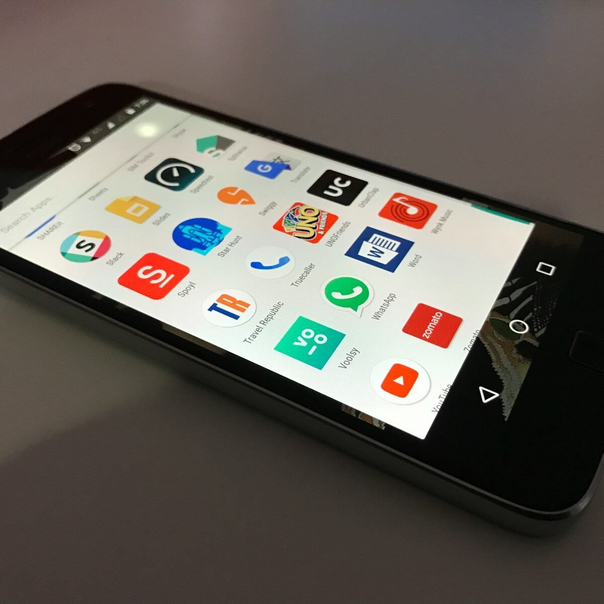 black Android smartphone lying on gray surface